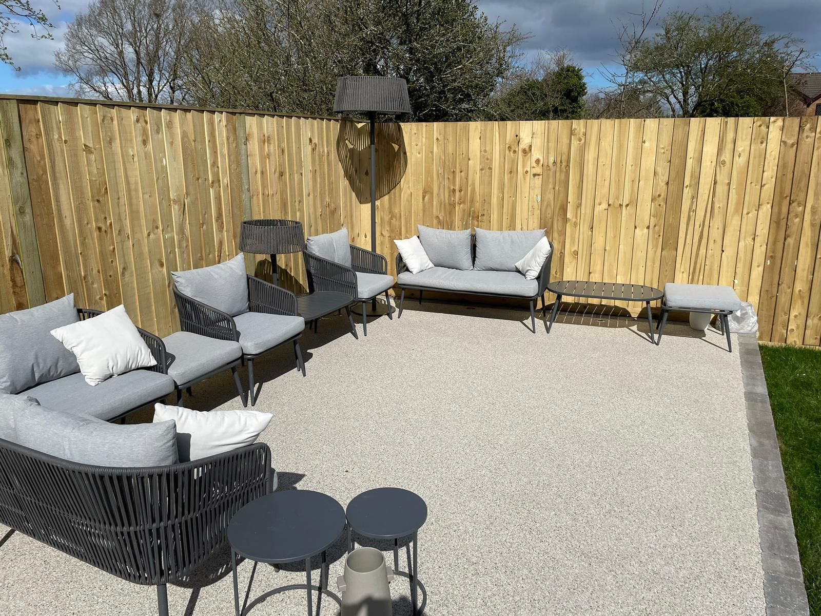 Chairs on a grey resin bound patio with block paving at the edges
