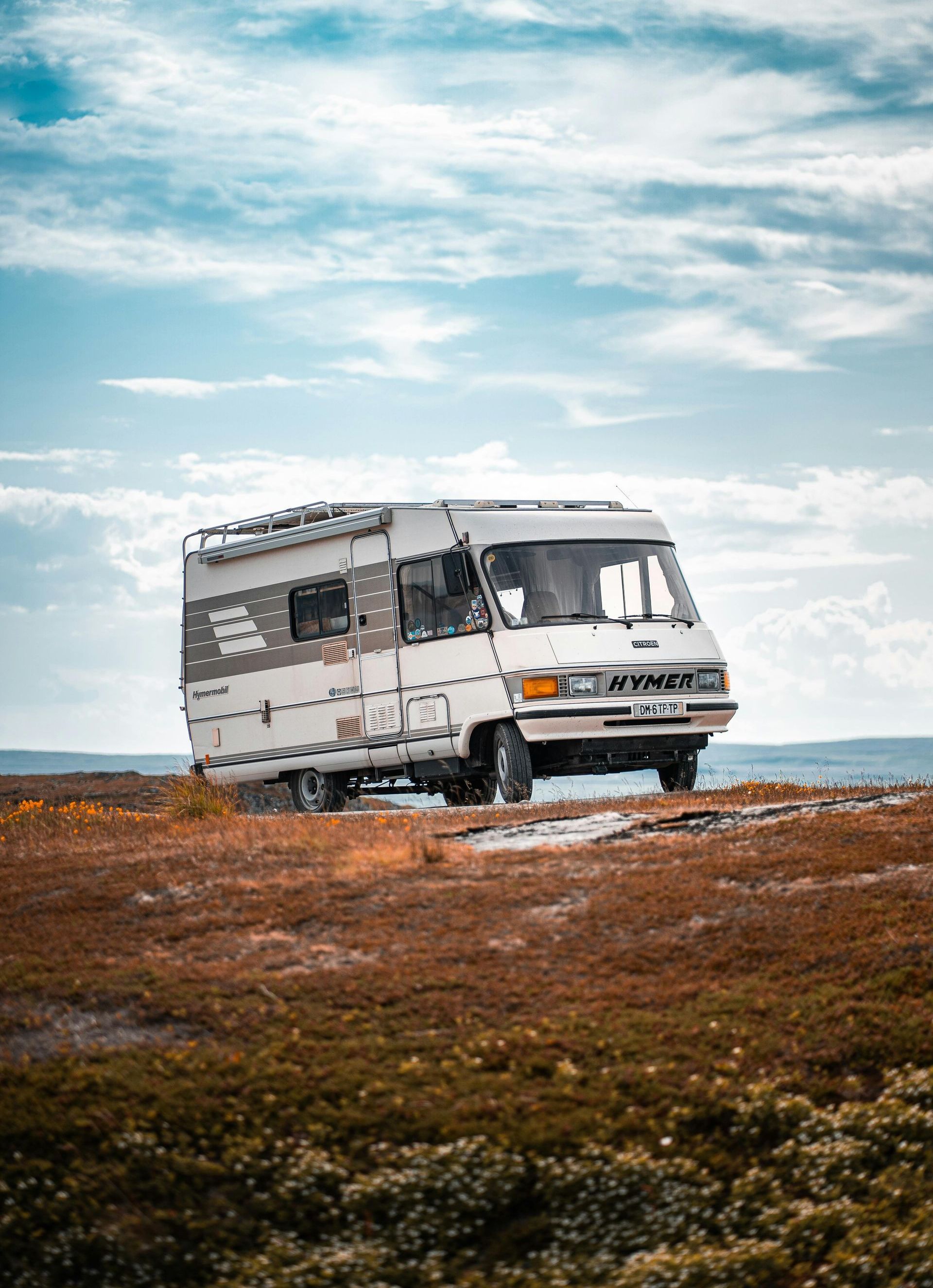 En hvid rv er parkeret midt på en mark.