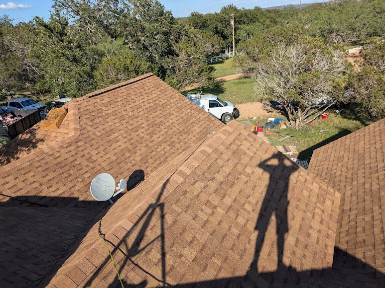 A shadow of a person is cast on the roof of a house.