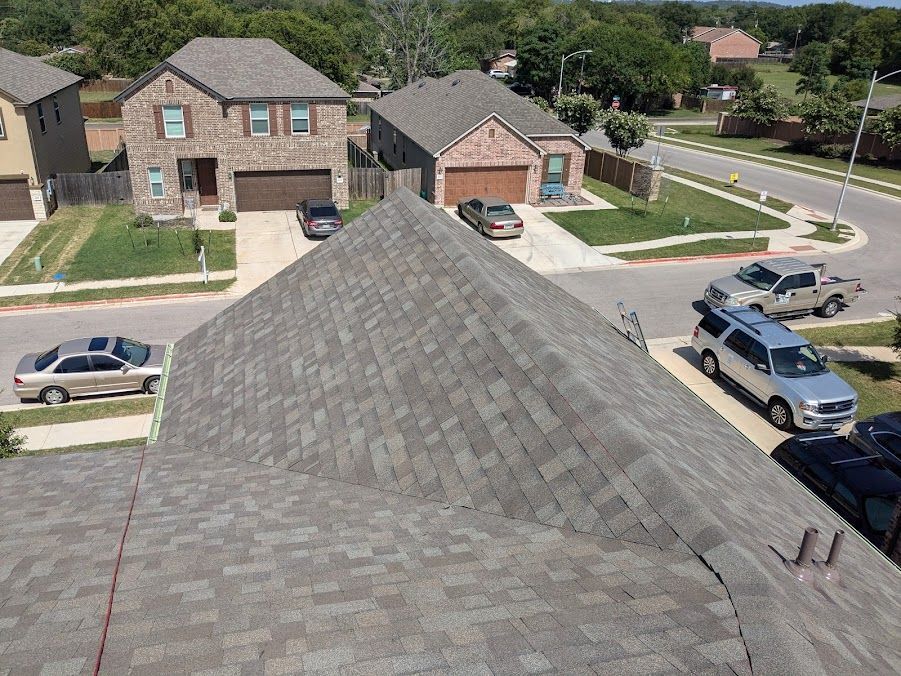 An aerial view of a roof of a house in a residential area.