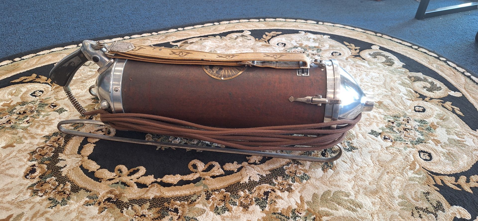 Brown leather handbag with silver handles on a patterned rug