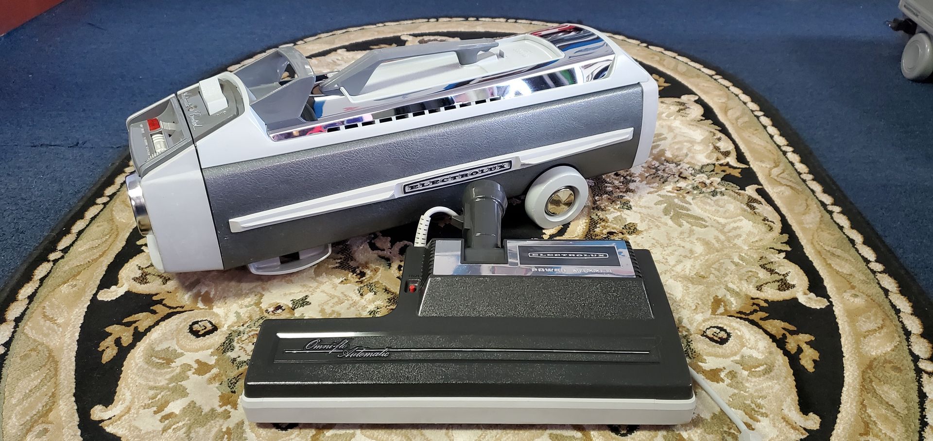 Compact silver camcorder and charger on a circular patterned cloth