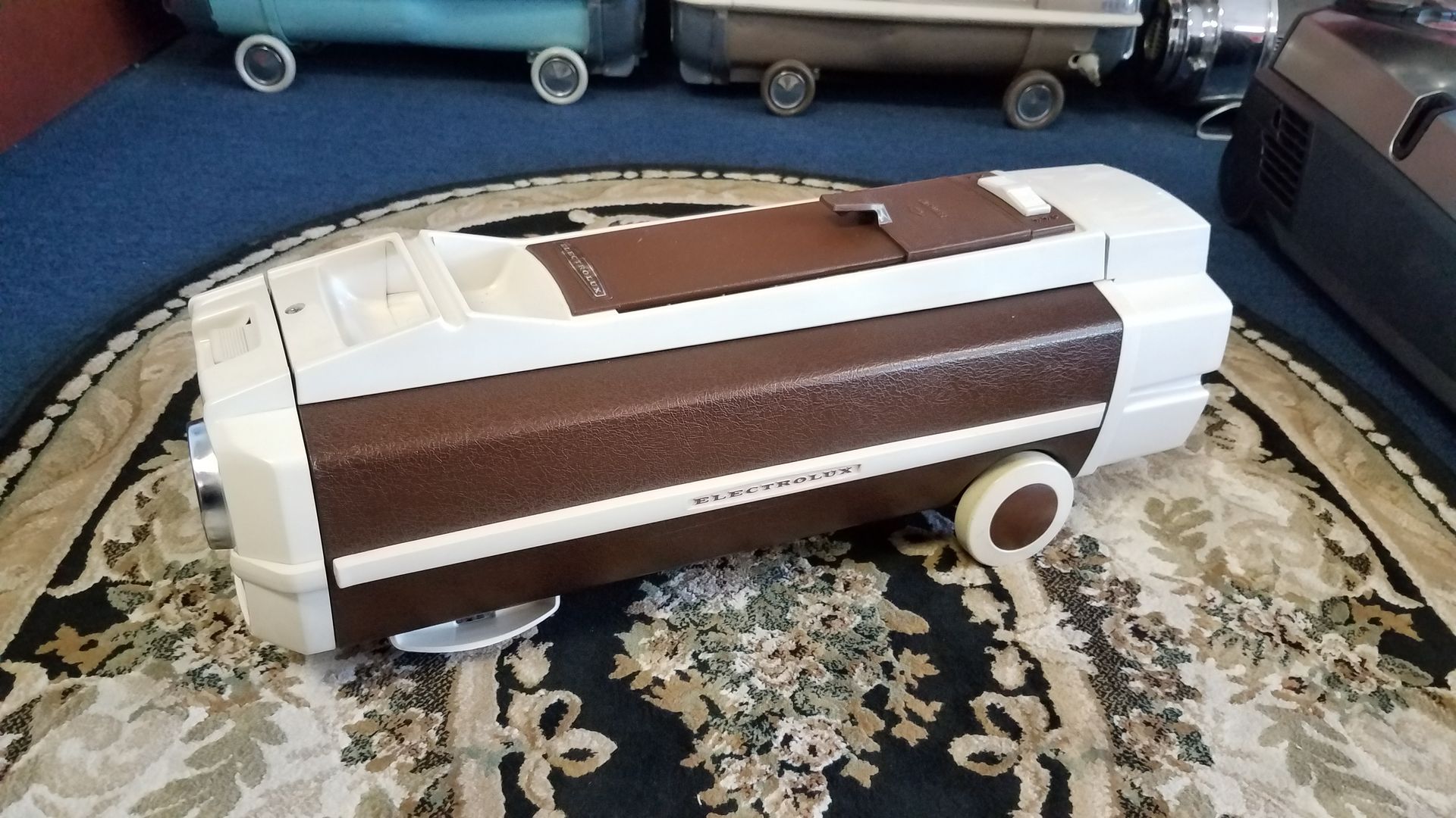 Brown-and-white toy van on a patterned rug in a living room