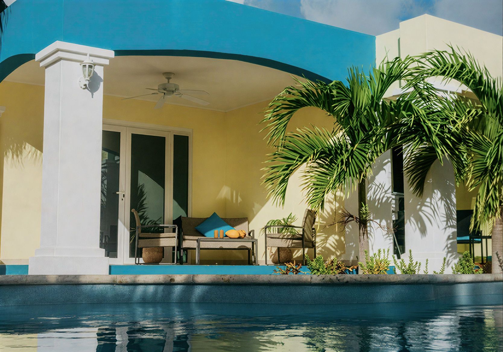 Modern villa patio with pool, white columns, blue arch, and palm trees
