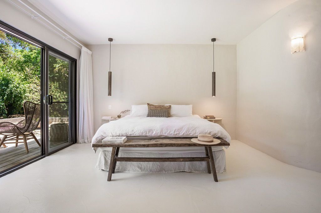 A Bedroom With A King Size Bed, Bench And Sliding Glass Doors — AH Electrical in Ballina, NSW