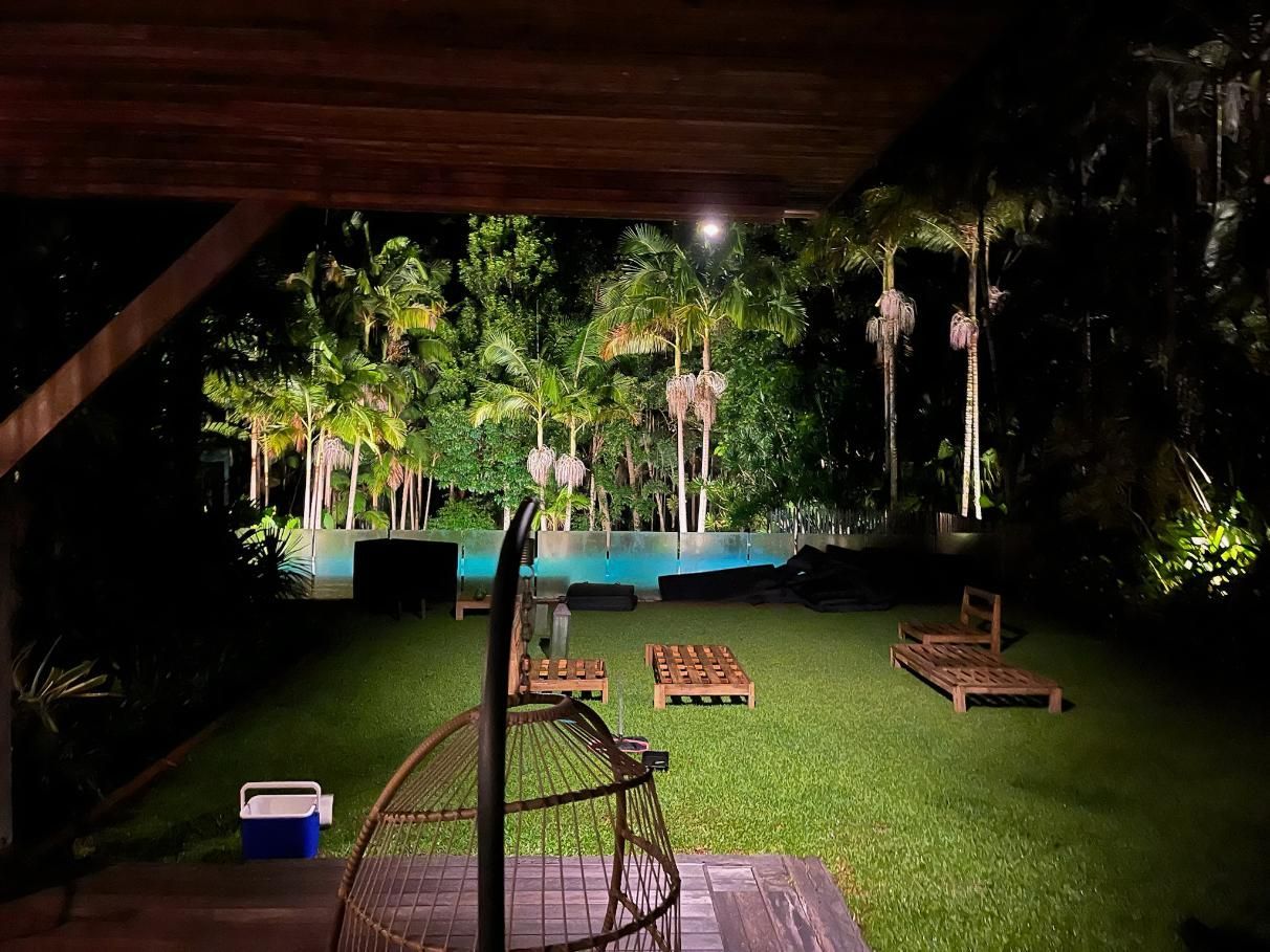 A Large Lawn With A Swimming Pool In The Background At Night — AH Electrical in West Ballina, NSW