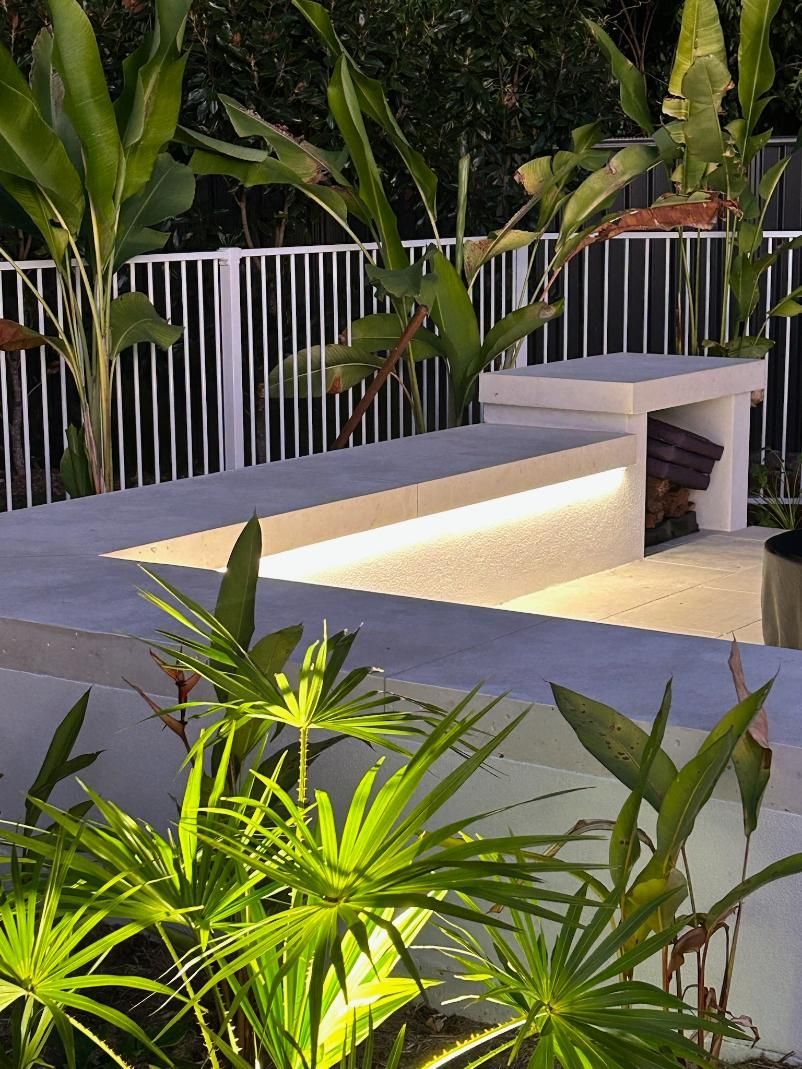 A Fence With A Bench And Plants In Front Of It — AH Electrical in Ballina, NSW