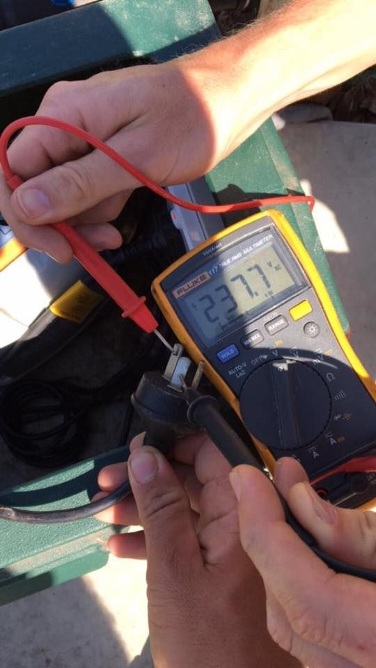 A Person is Using a Fluke Multimeter to Measure Voltage — AH Electrical in Ballina, NSW