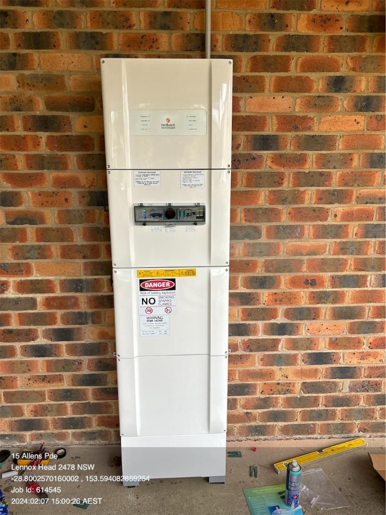 A Redback tech Smart Hybrid System Is Sitting In Front Of A Brick Wall — AH Electrical in West Ballina, NSW