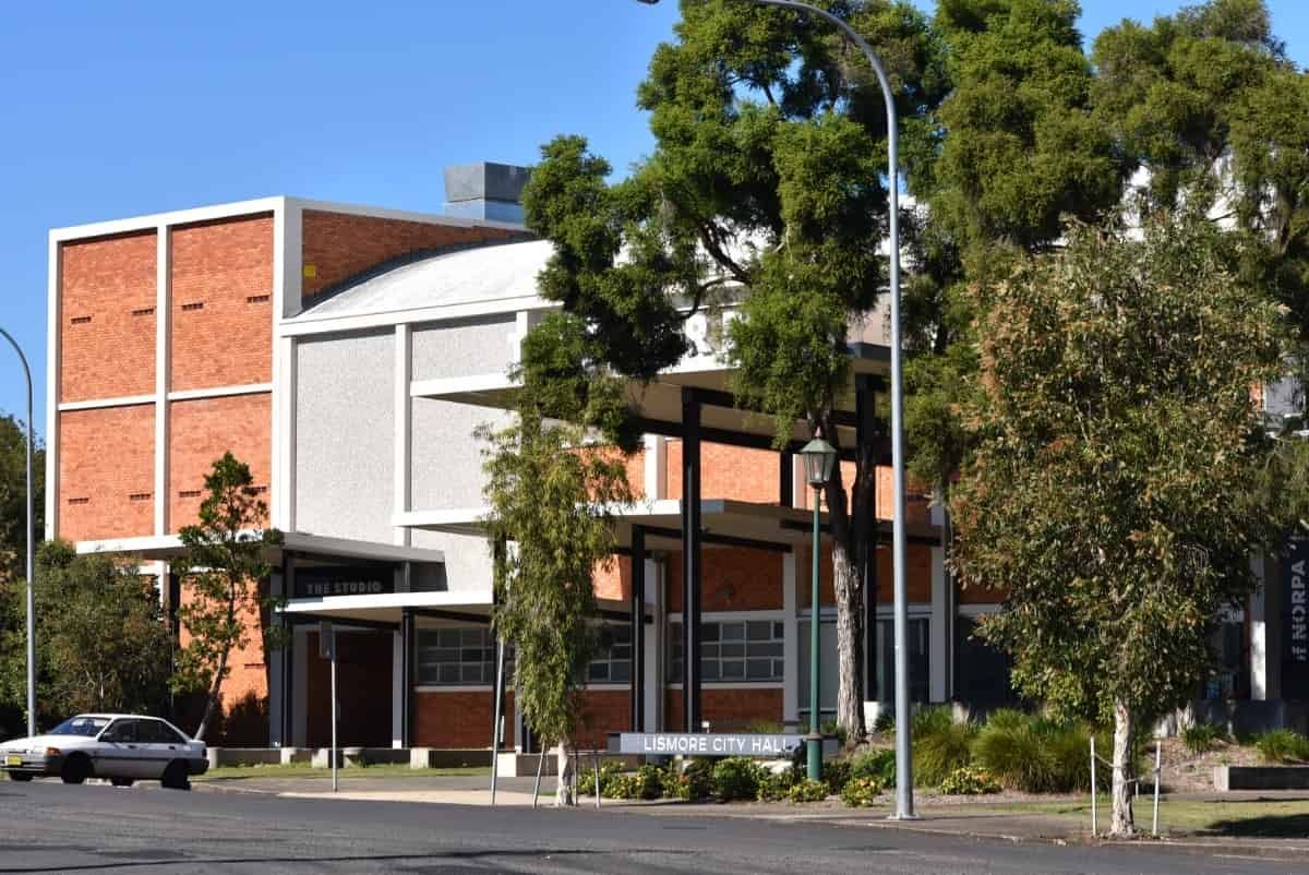 A Large Brick Building With a White Car Parked in Front of It — AH Electrical in Lismore, NSW
