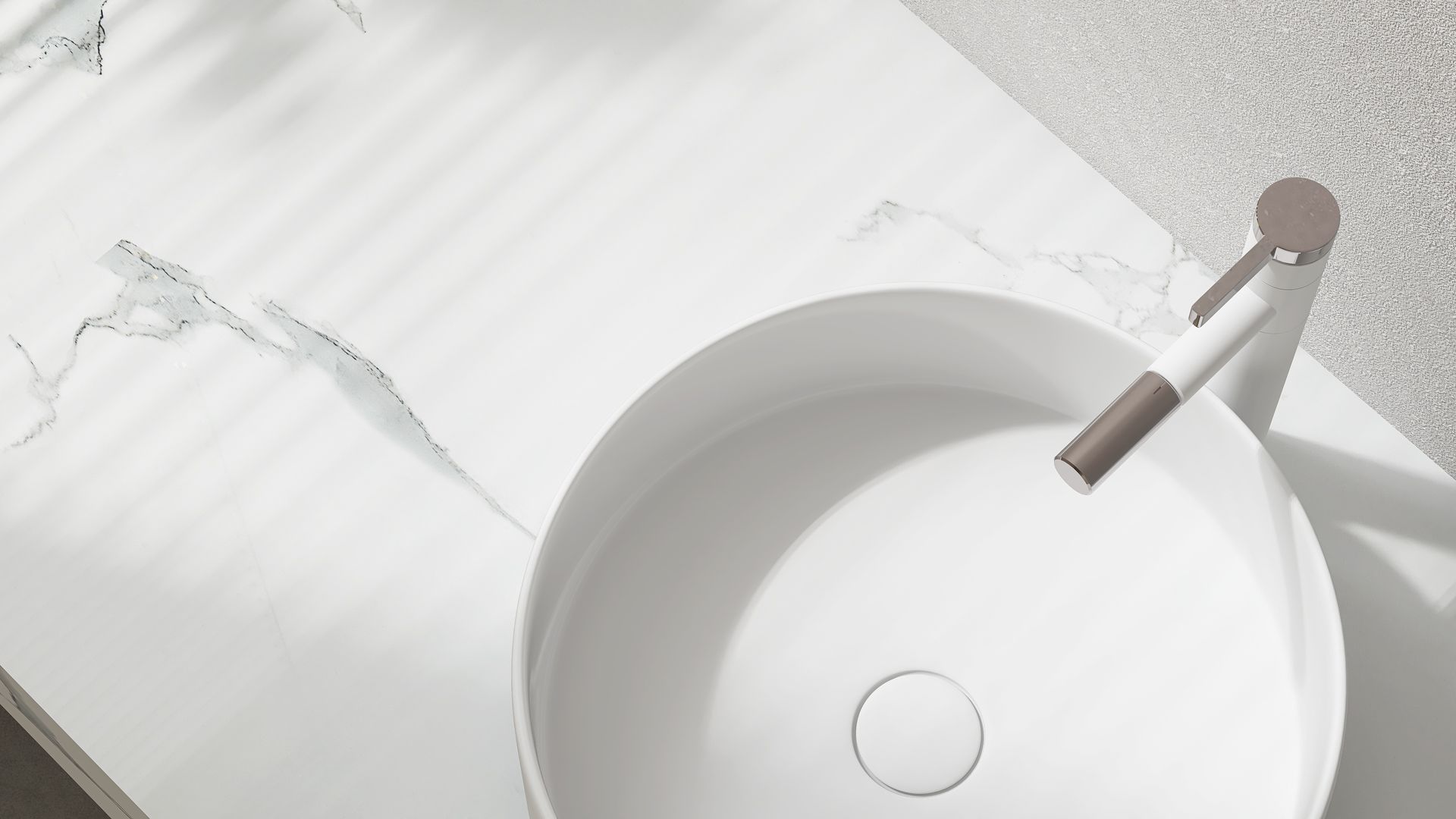 A modern white marble bathroom vanity with a sleek, minimalist vessel sink and a matte metallic faucet. A modern white marble bathroom vanity with a sleek, minimalist vessel sink and a matte metallic faucet.