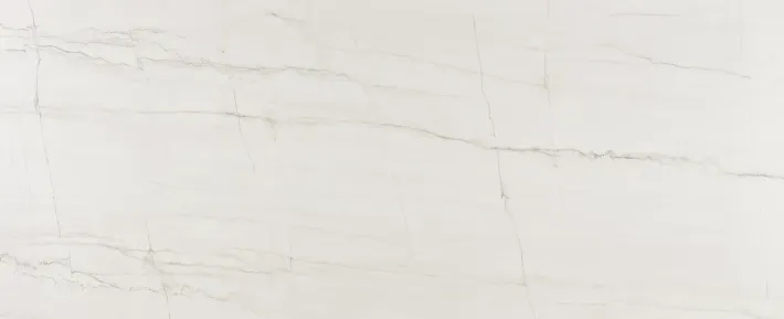 A close-up view of white marble stone with faint, soft grey veining throughout the smooth, polished surface. A close-up view of white marble stone with faint, soft grey veining throughout the smooth, polished surface.