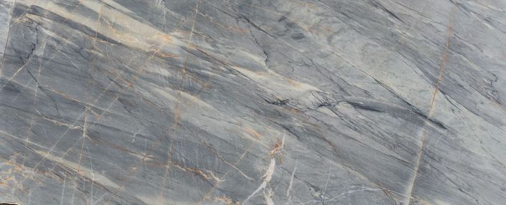 White marble surface with delicate, flowing gray veins across the texture. White marble surface with delicate, flowing gray veins across the texture.
