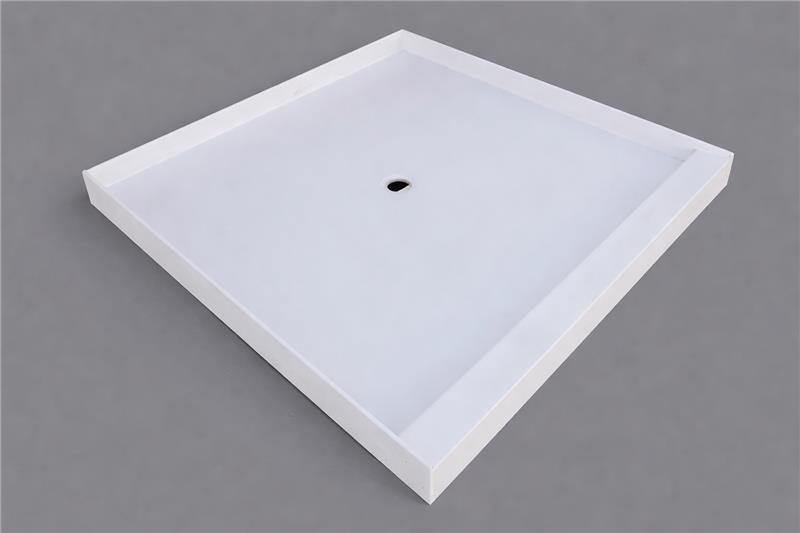 A white, square shower pan with a center drain hole against a plain gray background.