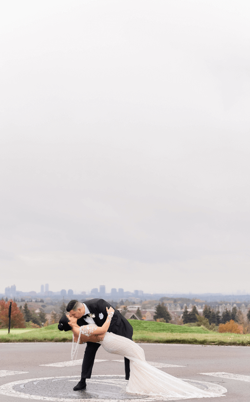 A married couple kissing at the Eagles Nest Golf Club helipad.