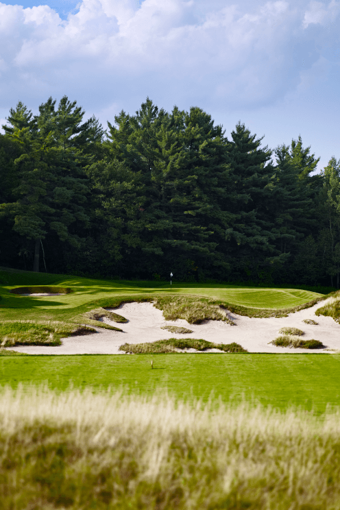 View of a hole's sand trap, green and flag.