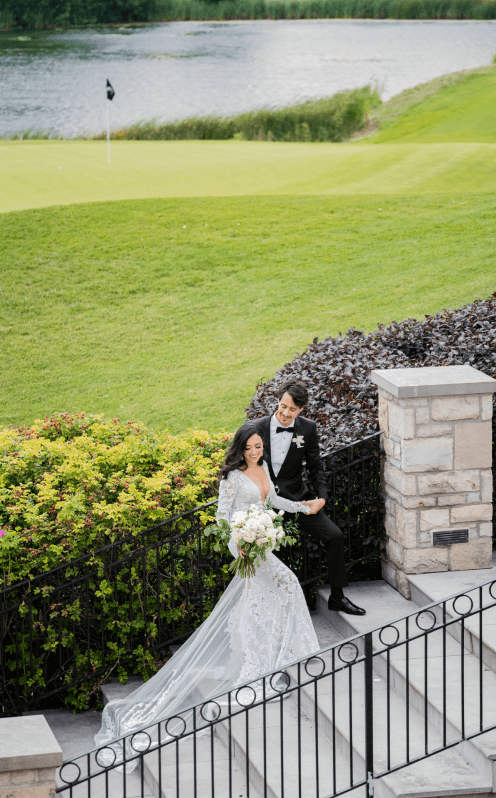 A married couple walking up large stone steps in the garden at Eagles Nest.