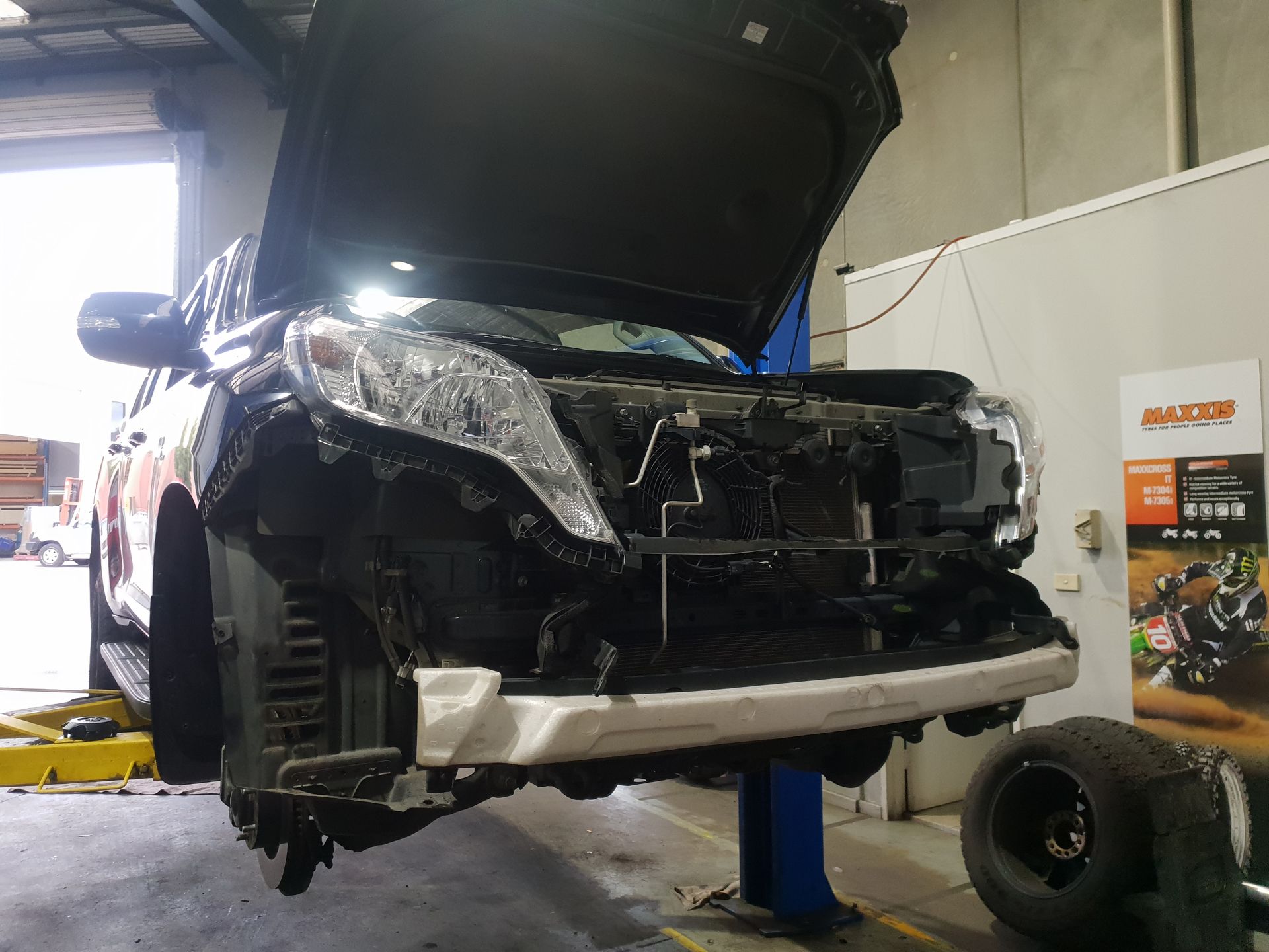 Damaged SUV in A Repair Shop, Front End Crushed, Hood Open, Tire Removed — Autoplus Professionals Picton in Picton, NSW