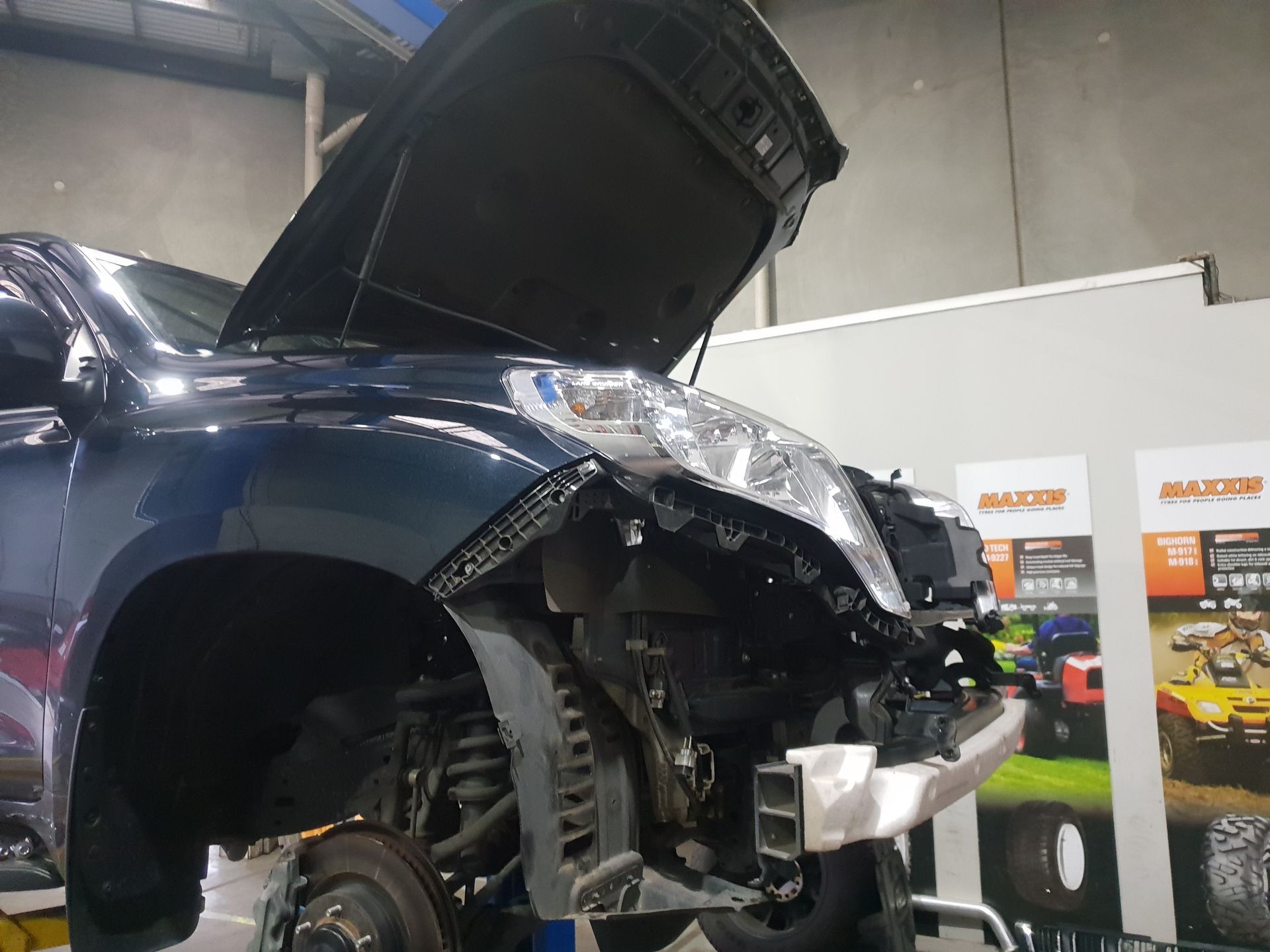 Blue Car in A Workshop with Front End Damage, Hood Open — Autoplus Professionals Picton in Picton, NSW