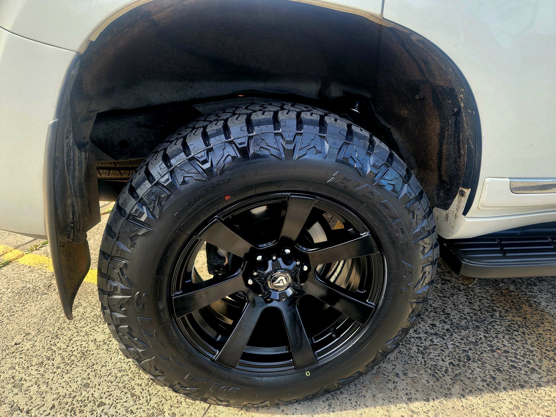 Black Tire and Rim on A White Car, Under the Wheel Well — Autoplus Professionals Picton in Picton, NSW