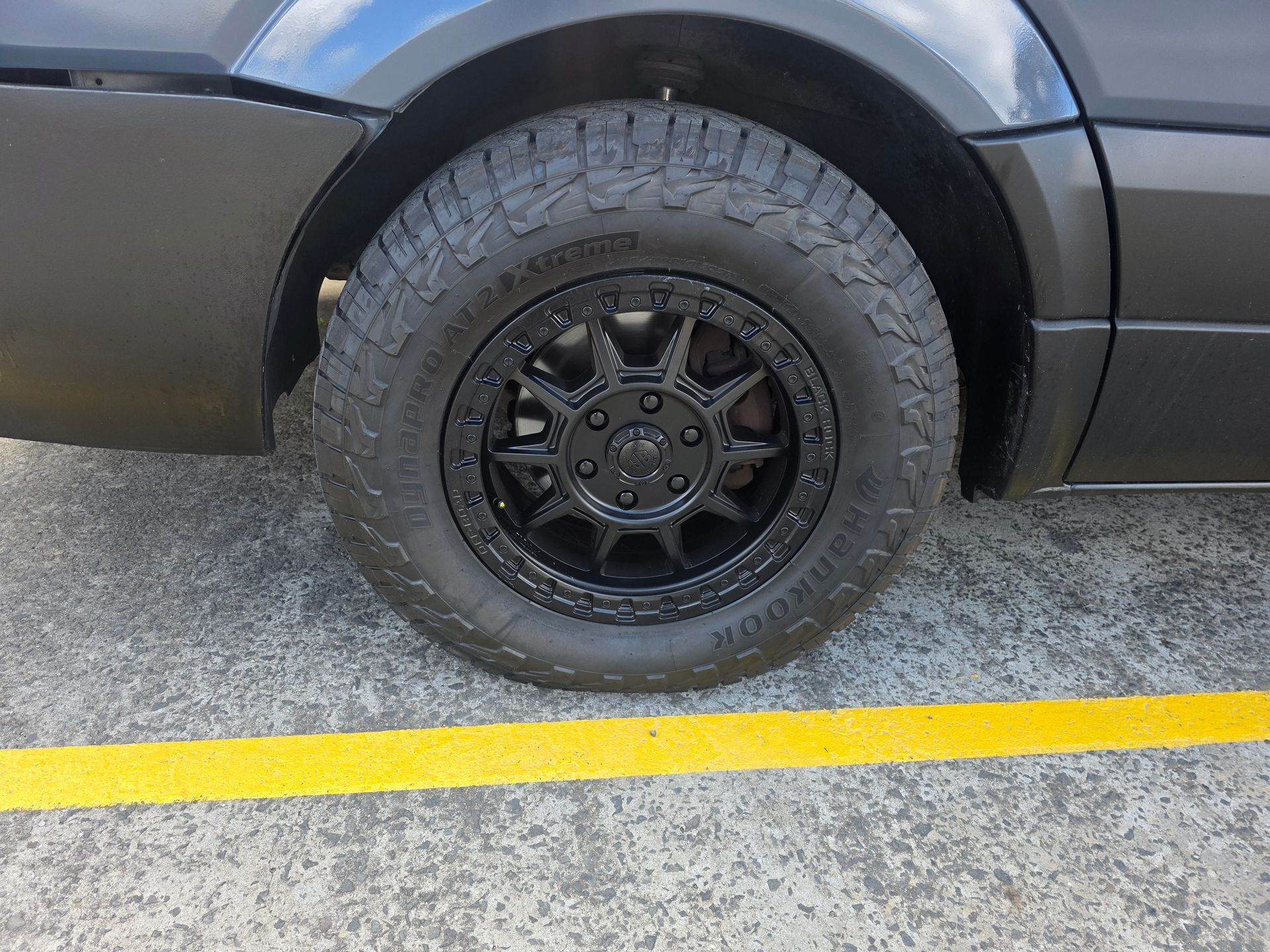 Black Vehicle Wheel on Pavement with A Yellow Line — Autoplus Professionals Picton in Picton, NSW