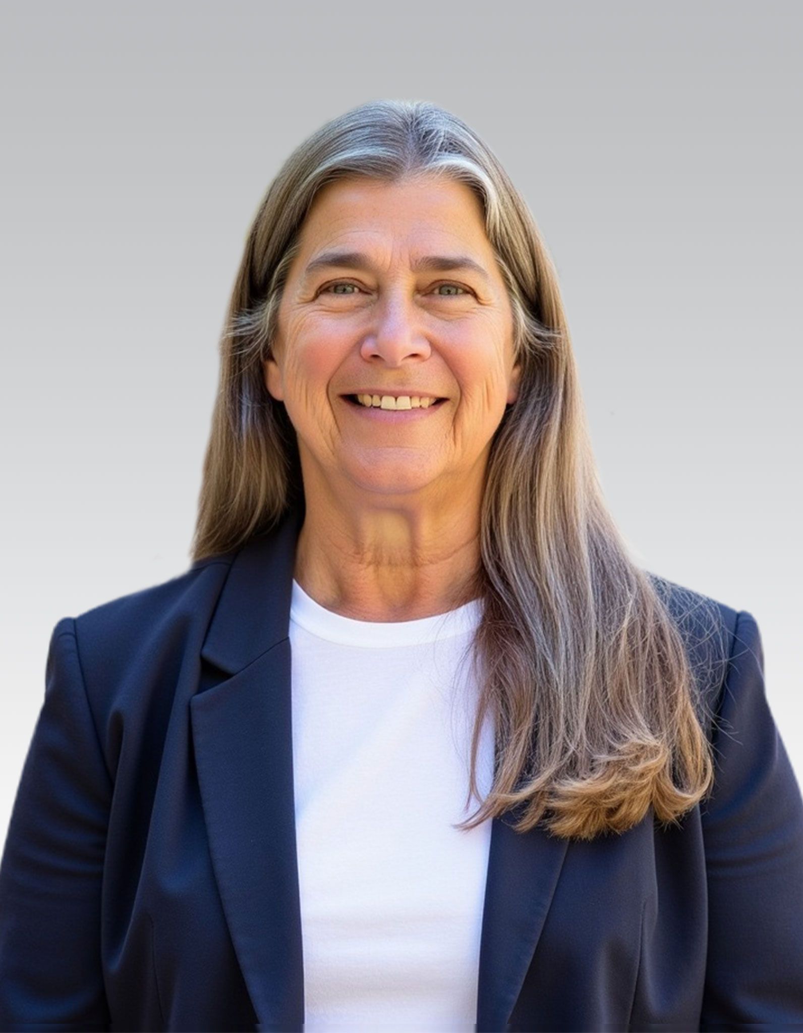 Smiling person in a navy blazer and white shirt against a plain light background