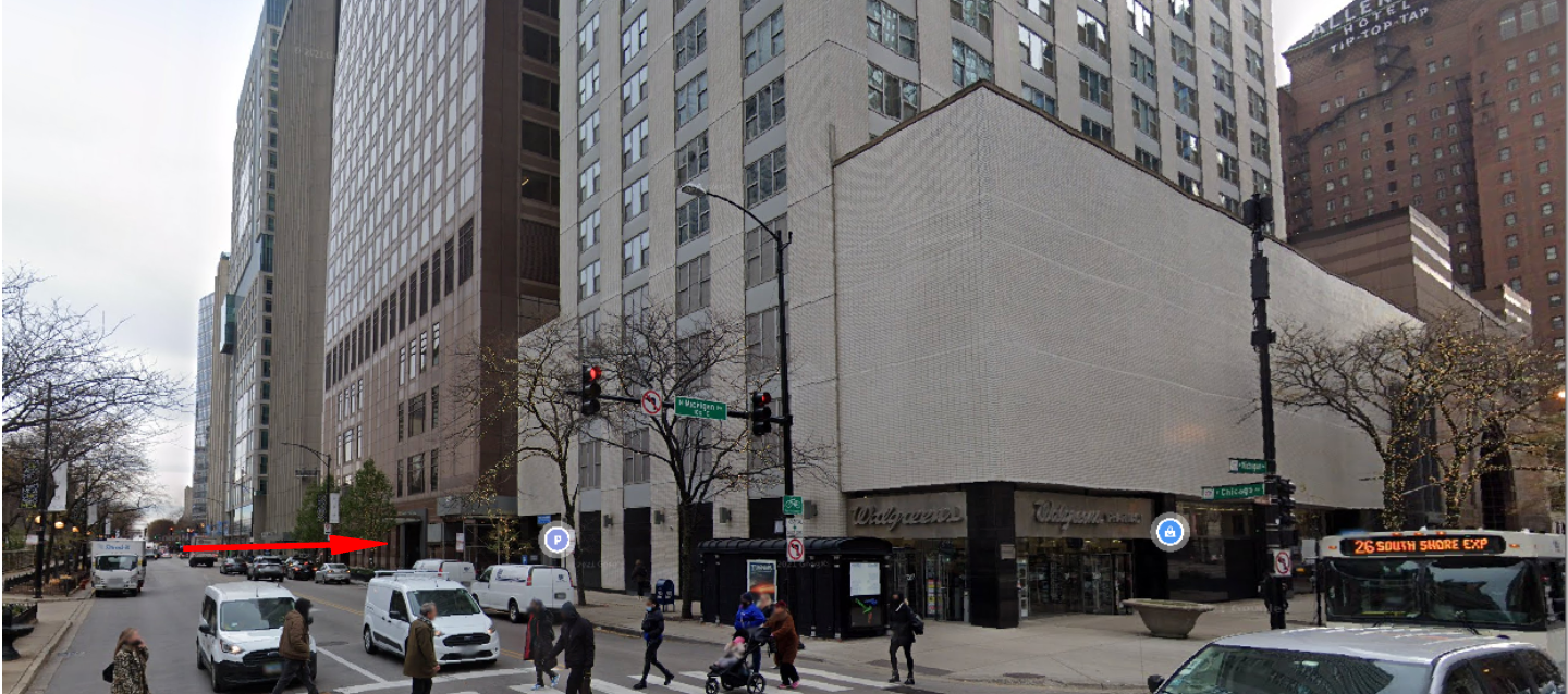 A busy city street with a large building in the background