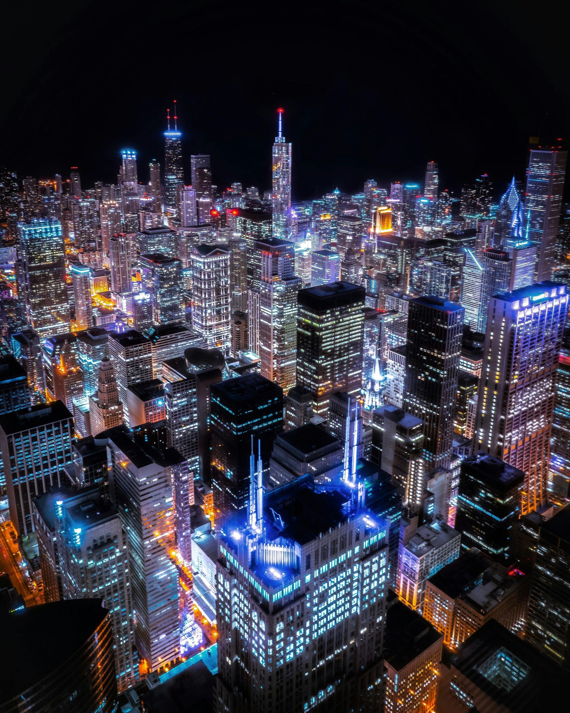 An aerial view of a city at night with lots of buildings lit up