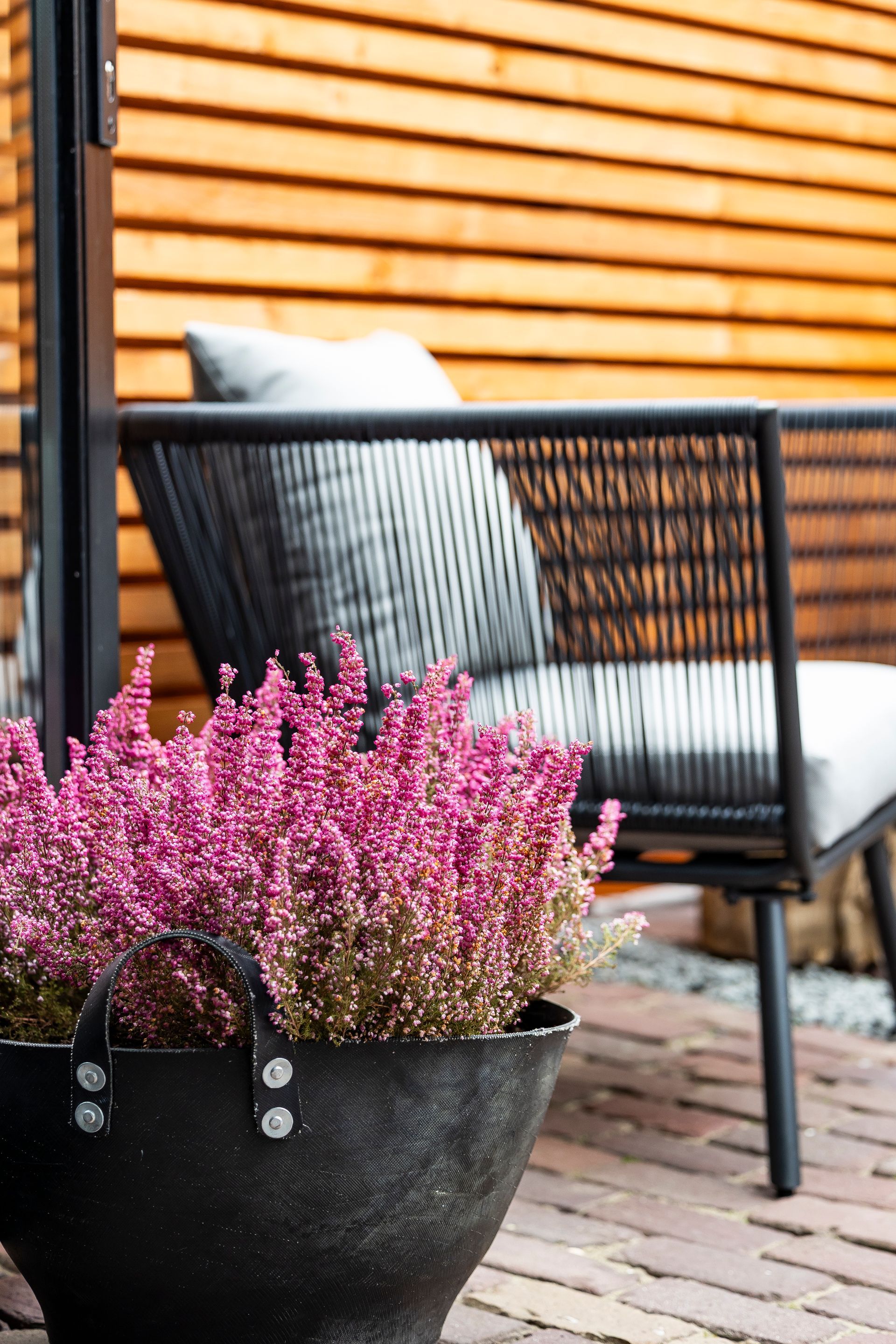 Loungebank met kussens op het terras tegen houten lamellenwand