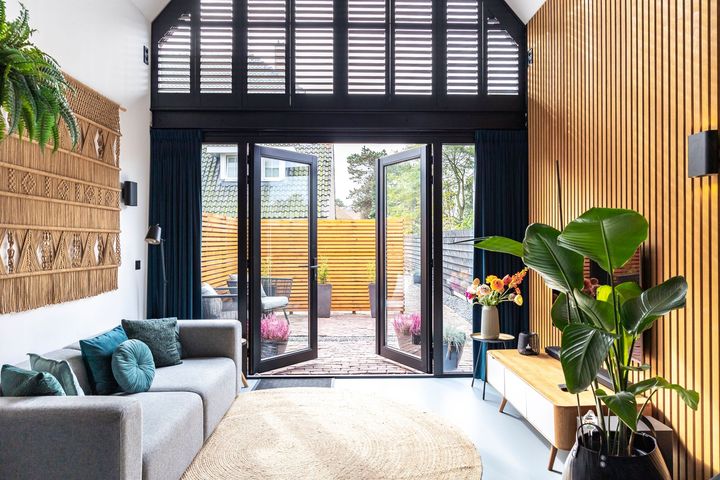 Woonkamer met openslaande deuren en trap in Résidence Beaufort, Zandvoort