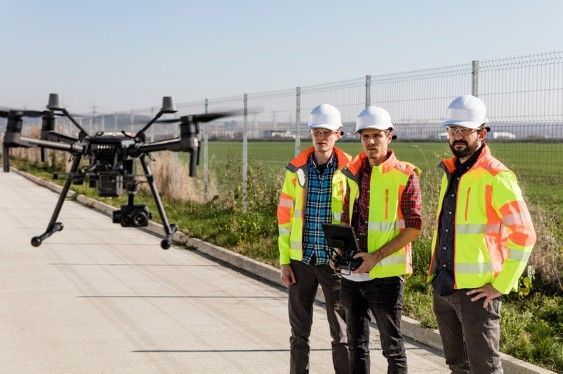 Working crew overseeing a flying drone