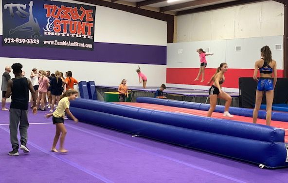 Tumble and Stunt Students in a Beginner Class with tumbling equipment