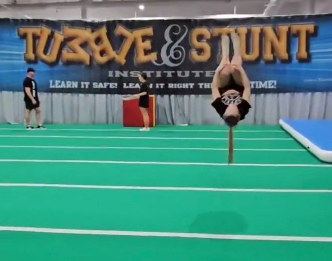 Grapevine Tumble and Stunt gym with a student practicing a tuck on the floor