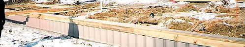 Construction site with concrete barriers along a curving edge, dirt, and earth.