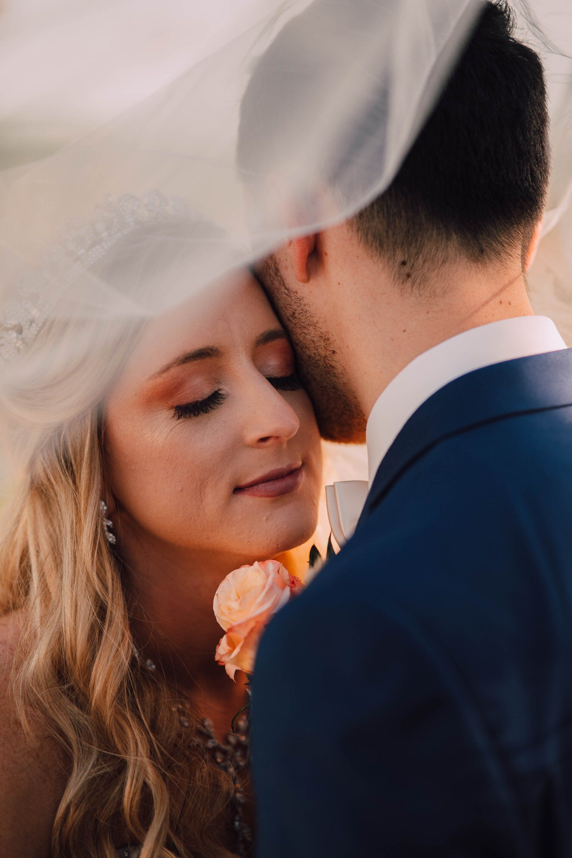Bride resting her cheek against her groom