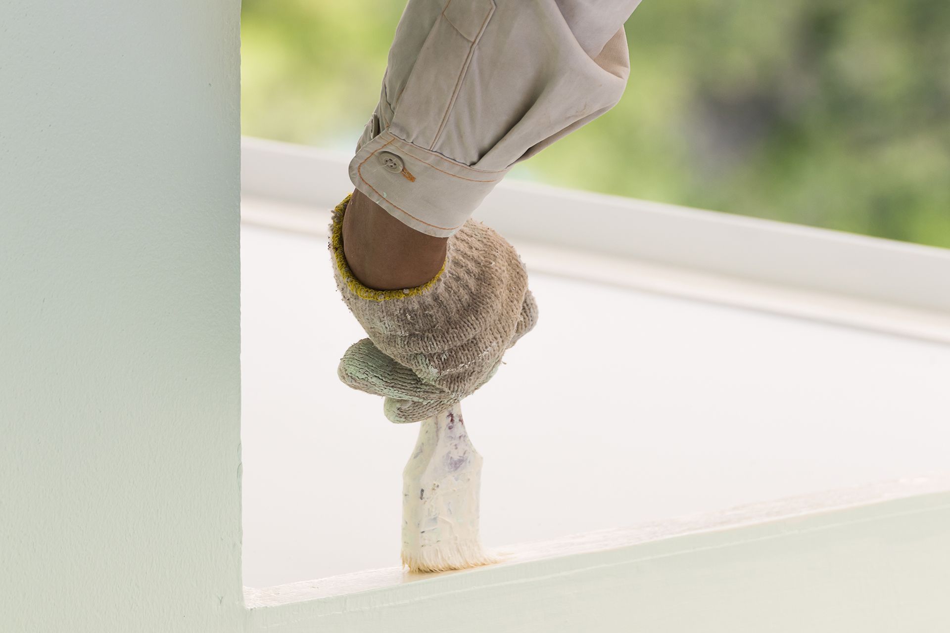 a person is painting a wall with a brush