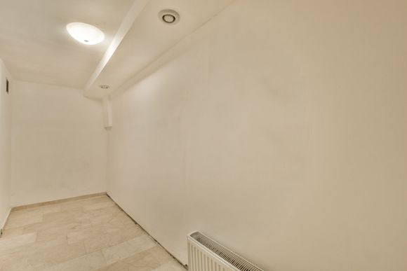 an empty room with a radiator and a light on the ceiling