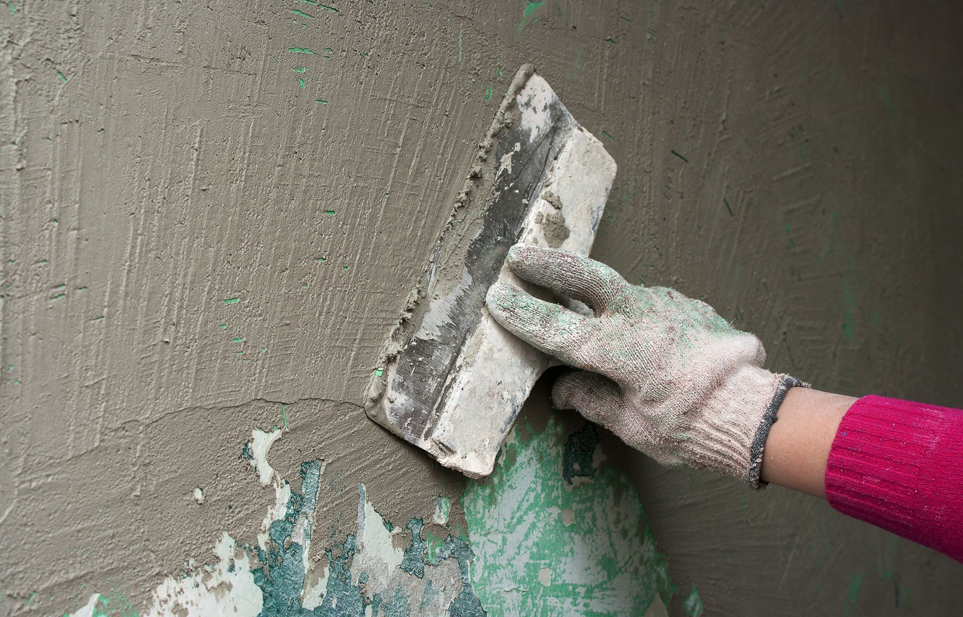 a person is using a trowel to plaster a wall