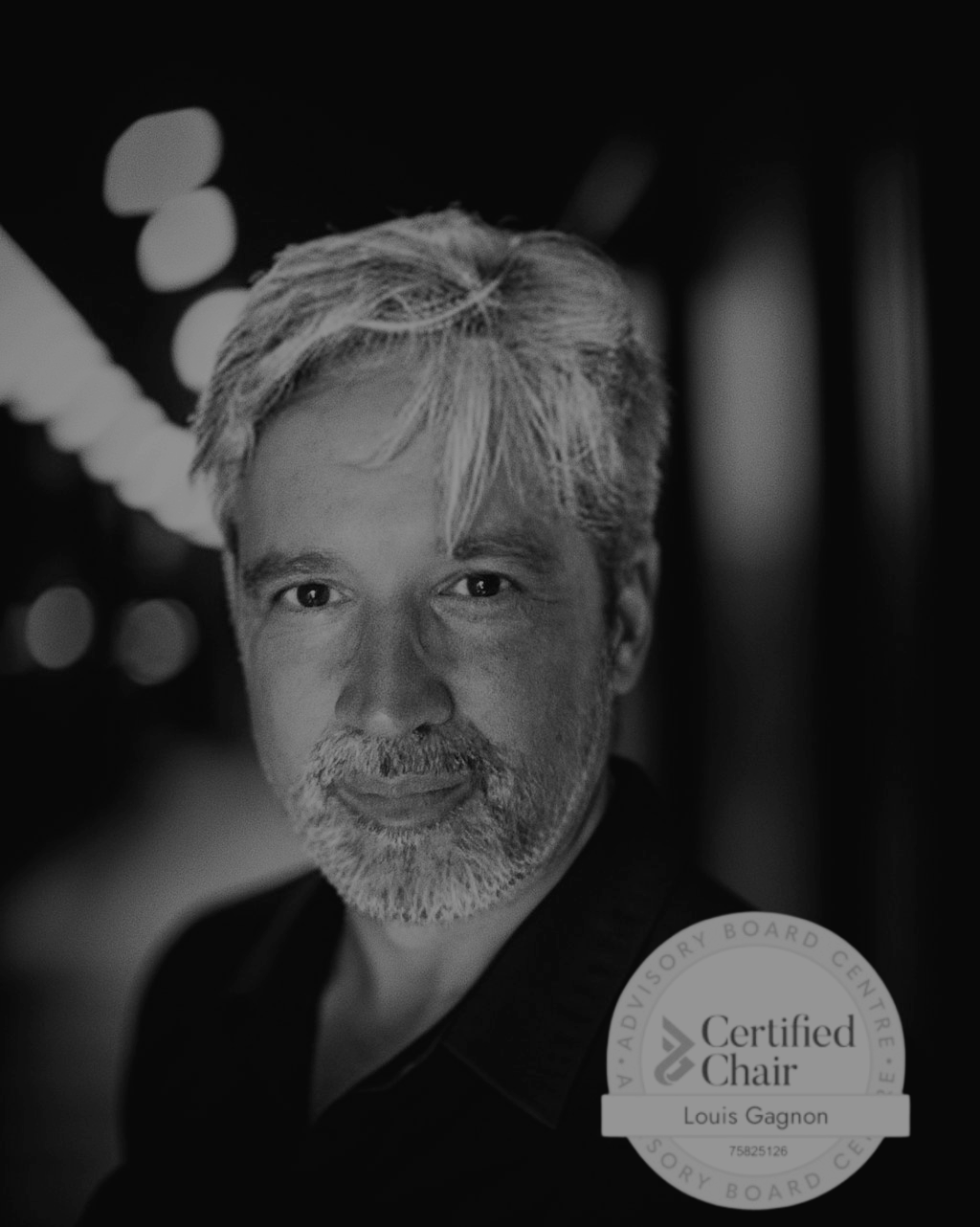 A man with a beard is wearing a certified chair badge.