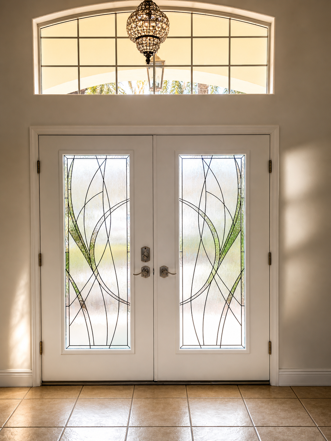 Front entry with white double doors, frosted glass panels, and a hanging chandelier above.