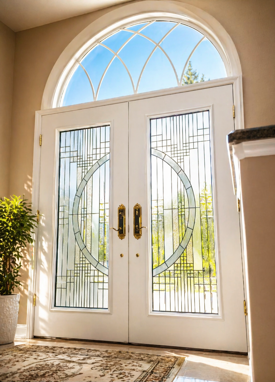 White double front doors with glass panels and gold handles beneath an arched transom window.