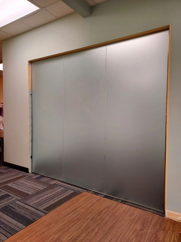 A room with a large glass wall and a wooden floor.