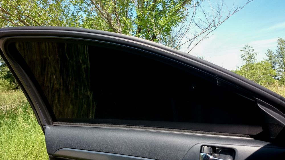 a Car With a Black Window is Parked in a Field With Trees in the Background — Total Tint Bendigo in East Bendigo, VIC