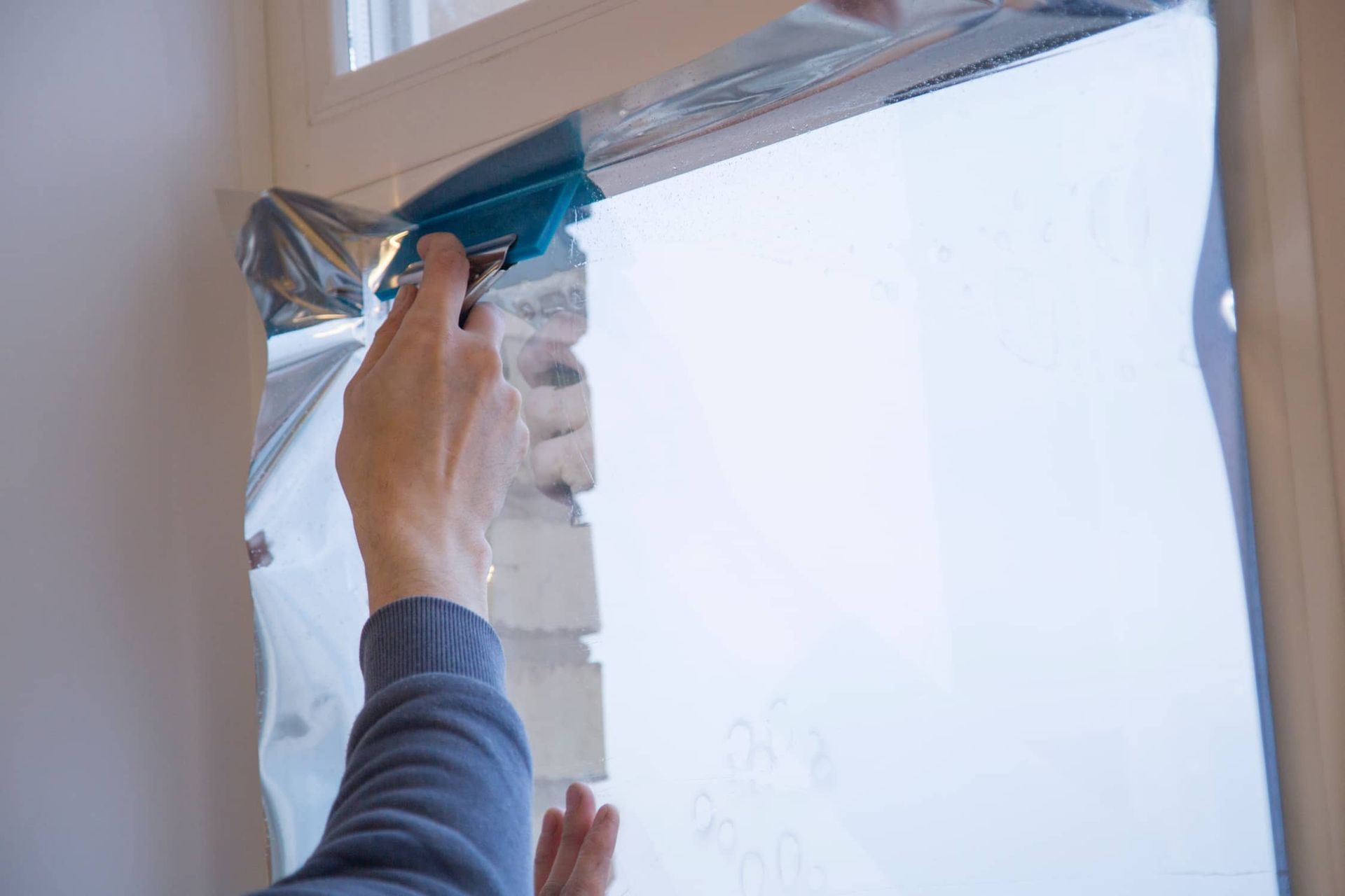 a Person is Applying Tinted Glass to a Window — Total Tint Bendigo in East Bendigo, VIC