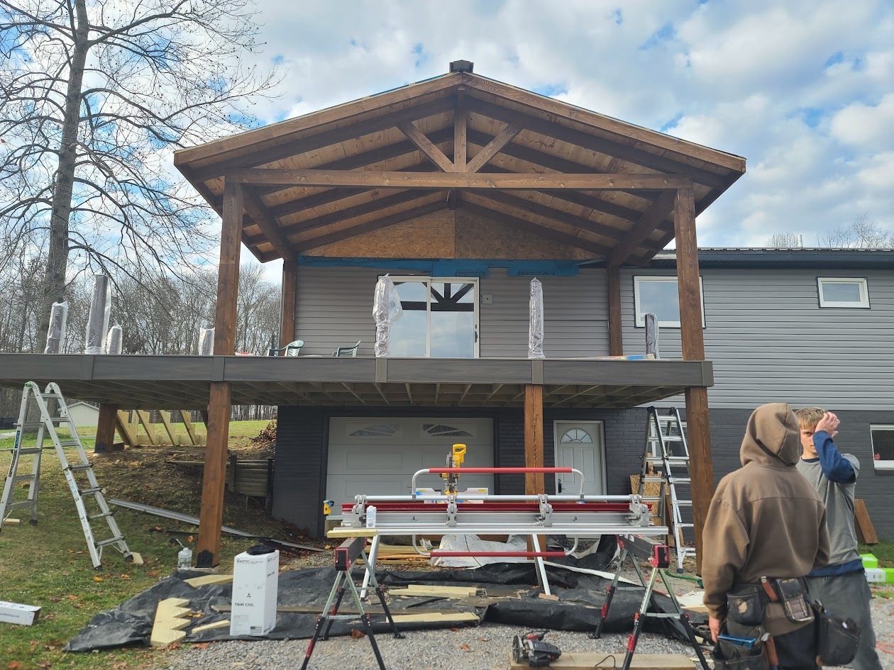 A man is standing in front of a house under construction.