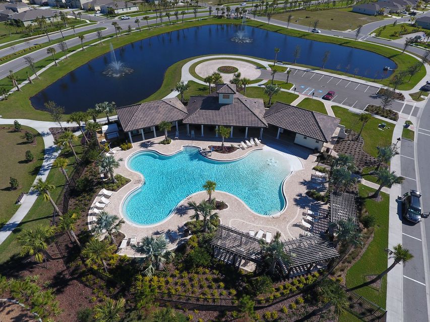 An aerial view of a large swimming pool surrounded by trees and a lake.