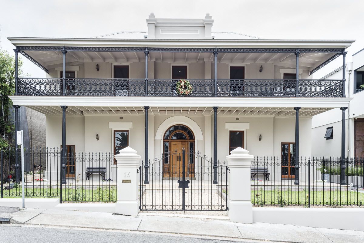 A large white house with a black fence around it.