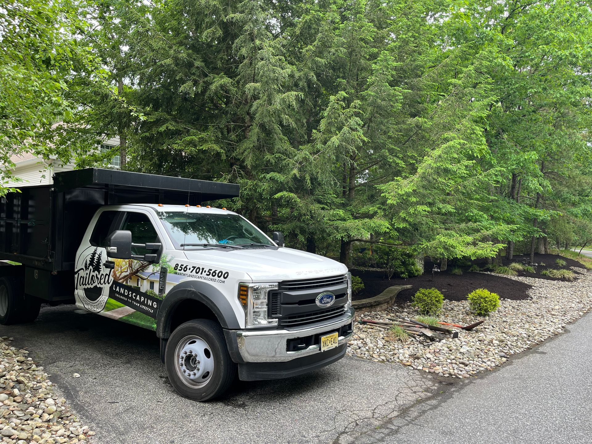 White vehicle door with “Tailored Properties” logo and trees, partial “Installation” text visible