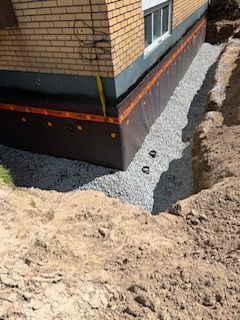 Fondations de la maison avec étanchéité et tranchée de drainage en gravier en construction