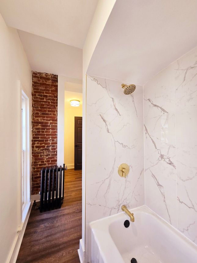 Beautiful marble tile shower in renovated apartment inside the Lewis Miller Mansion.